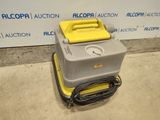 l'image d'une machine jaune et grise posée sur un sol en ciment