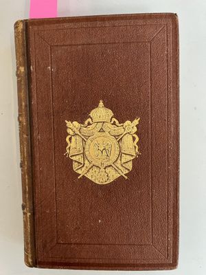 an old brown book with a gold emblem on it