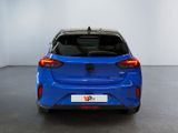 the rear end of a blue car in a white room
