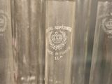 several clear glass vases are lined up on a shelf