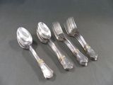 cinq cuillères en argent et deux cuillères en argent sur une table