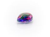 a rainbow colored stone sitting on top of a white surface