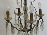 a person holding a chandelier with several lights hanging from it