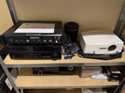 une étagère sur laquelle sont posés une chaîne hi-fi et d'autres appareils électroniques