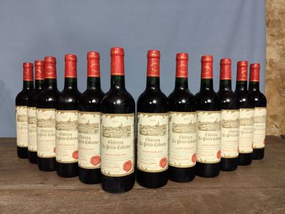 six bottles of red wine are lined up on a wooden table