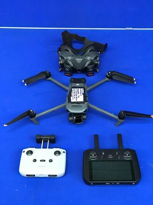 un drone noir et blanc et un téléphone portable posés sur une surface bleue