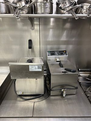 des casseroles et des poêles posées sur une étagère dans une cuisine