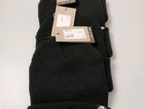 three black beanies stacked on top of each other on a table