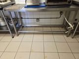 une table en acier inoxydable sur laquelle est posé un grille-pain, dans une cuisine