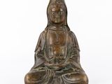 une statue en bronze représentant une femme assise en position du lotus
