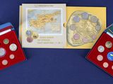 two boxes of coins and a card with a picture of a map on them