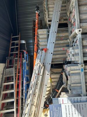 de nombreuses échelles empilées à l'arrière d'un camion
