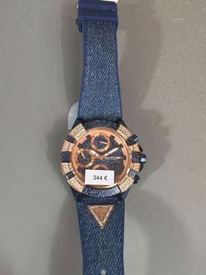 une photo d'une montre posée sur une table, avec une étiquette accrochée dessus