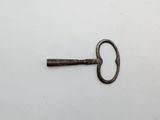 a close up of an old key on a white surface