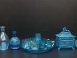de nombreux vases en verre bleu posés sur une table