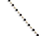 un bracelet composé de perles dorées et noires sur fond blanc