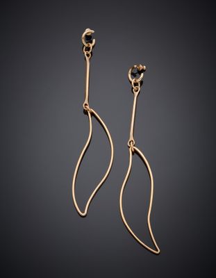 une paire de boucles d'oreilles en or sur fond noir