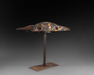 une sculpture en bronze représentant un poisson, posée sur un socle en métal