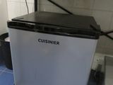 a small white refrigerator sitting on a blue tiled floor