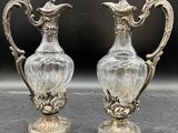 deux vases en argent posés l'un à côté de l'autre sur une table