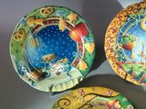 three plates with designs on them sitting on a table
