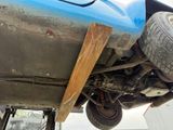 a blue car with a wooden bumper underneath it
