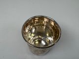 a silver cup that is sitting on a table