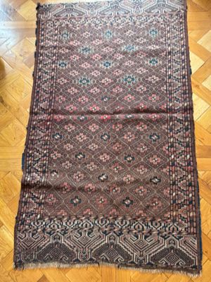 un tapis posé sur le sol, avec un parquet en arrière-plan