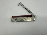 a metal comb with a wooden handle on a white surface