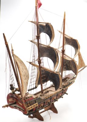 a wooden model of a ship on a white surface
