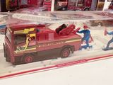 a toy fire truck with a man and a fireman in it
