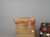 pair of brown vases with floral designs on them against a gray background