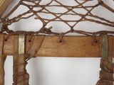 a close up of a piece of wood with a net hanging from it