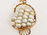 a picture of a gold and pearl pendant on a white background