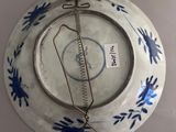 a blue and white plate with a wire hanging from it