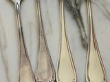 five forks and a knife on a marble table