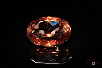 un diamant orange sur une surface noire
