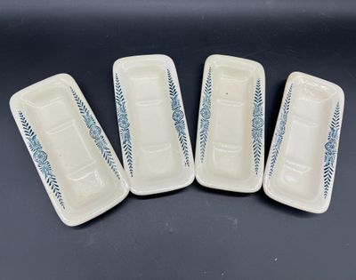 quatre assiettes blanches ornées de motifs bleus, posées sur une table