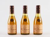 three bottles of wine sitting next to each other on a white surface