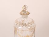 a glass bottle with a gold design on it