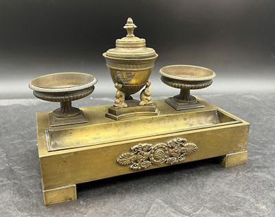 un bougeoir de couleur dorée surmonté de deux coupelles