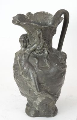 un petit vase orné d'une statuette, posé sur une surface blanche