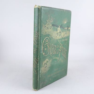 un vieux livre vert posé sur une table blanche