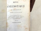 un vieux livre posé sur une table à côté d'une pile de livres