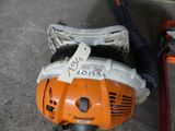a chainsaw and a blower sitting on the ground