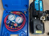 une boîte bleue contenant un tuyau bleu et deux manomètres