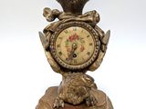 a gold clock with a crown on top of it