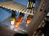 many bottles of wine sitting on a shelf in a room