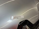 the back end of a silver car with a sticker on it ' s hood