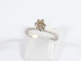 un gros plan d'une bague sertie d'un diamant sur un fond blanc